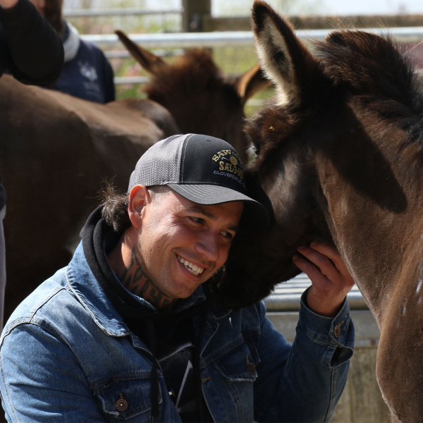 Member of team from Oscar's Place cuddling donkey.